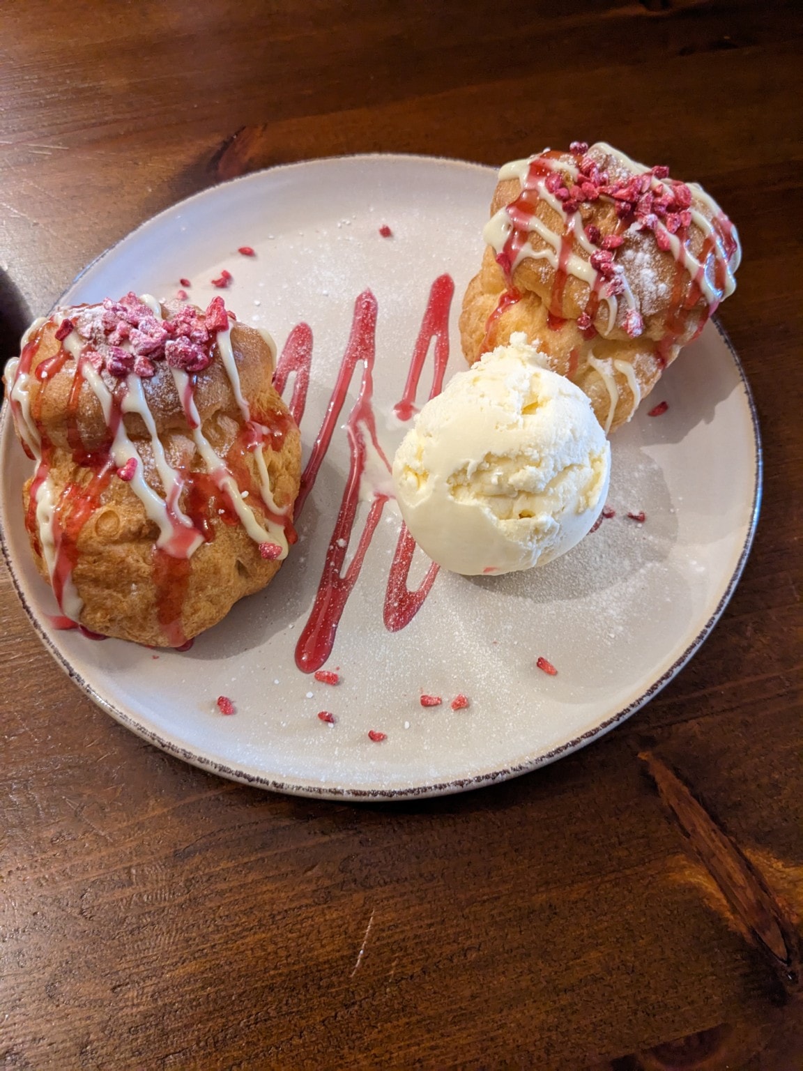 Choux pastry buns with raspberry sauce and ice cream