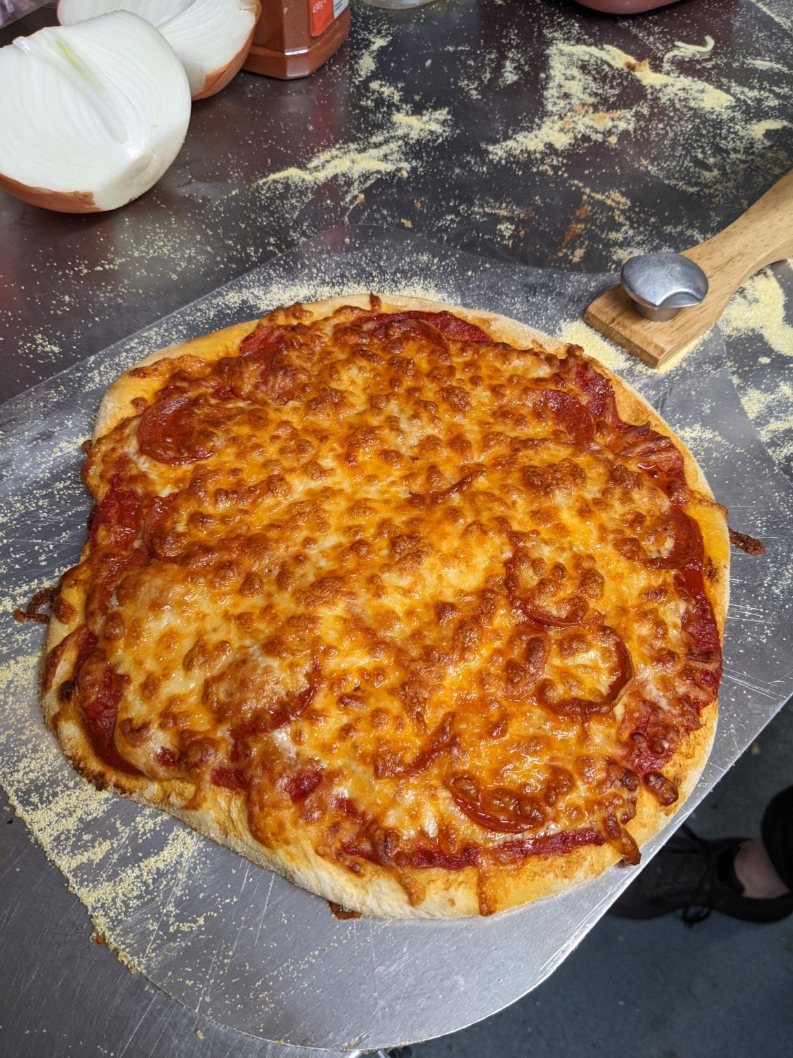 Fresh pizza on a floured peel ready for the oven